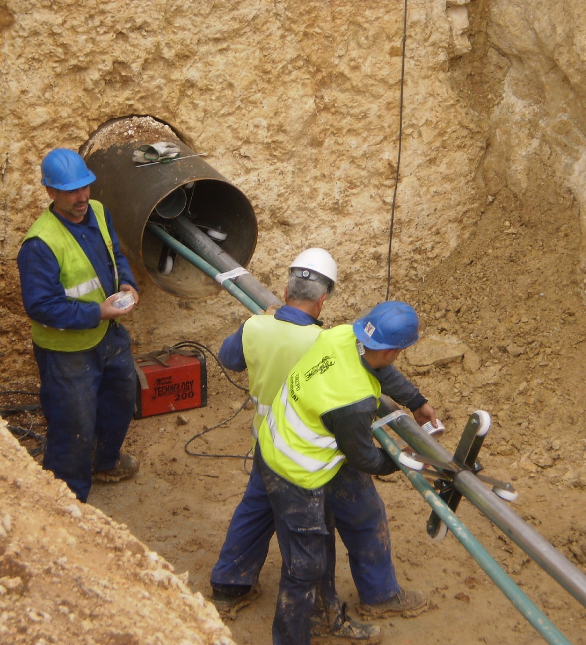 Operarios instalando una conducción en una zanja