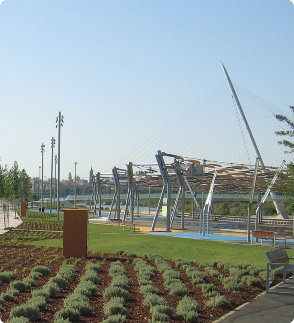 Parque urbano con estructuras metálicas al fondo